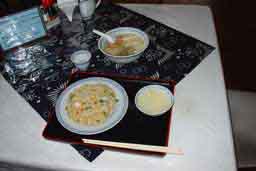 筑紫野市塔原西の中華料理屋さん「福禄飯店」。テーブルの上に炒飯と卵スープが乗ったお盆、その奥には汁そばのどんぶり