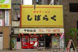 福岡市中央区大手門のラーメン屋さん「しばらく」。伝統的なラーメン屋さんの店構え。黄色のテントに赤で唐草の縁取りがしてあります