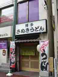 福岡市中央区大名のうどん屋さん「博多さぬきうどん」。間口１間の入り口、幟や提灯が下がっています。